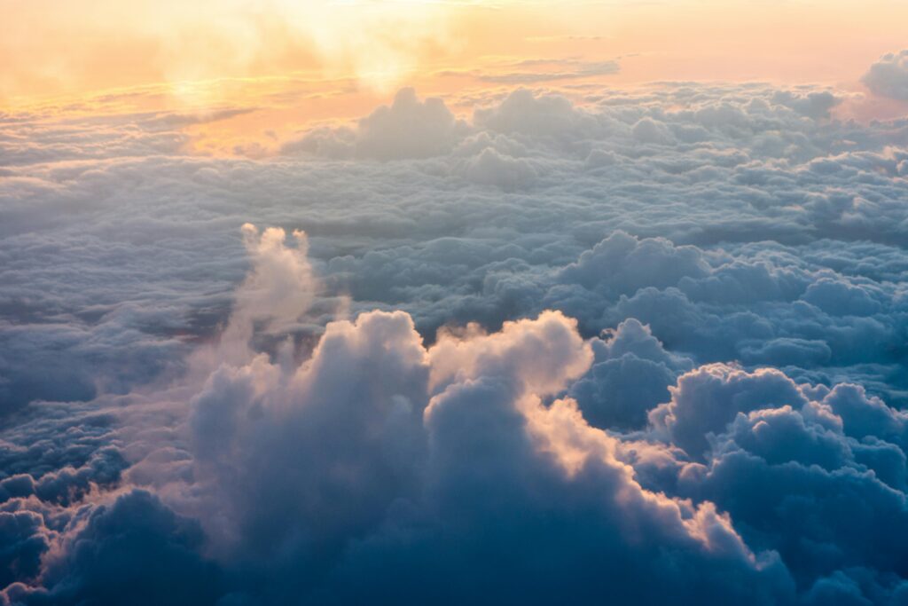 Stunning aerial view of sunlit clouds during sunrise, creating a tranquil and dramatic atmosphere.